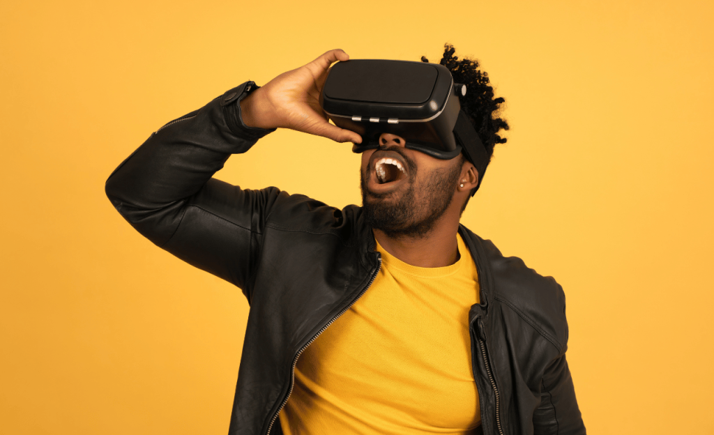 Man wearing a virtual reality headset, stood in front of a bright yellow background